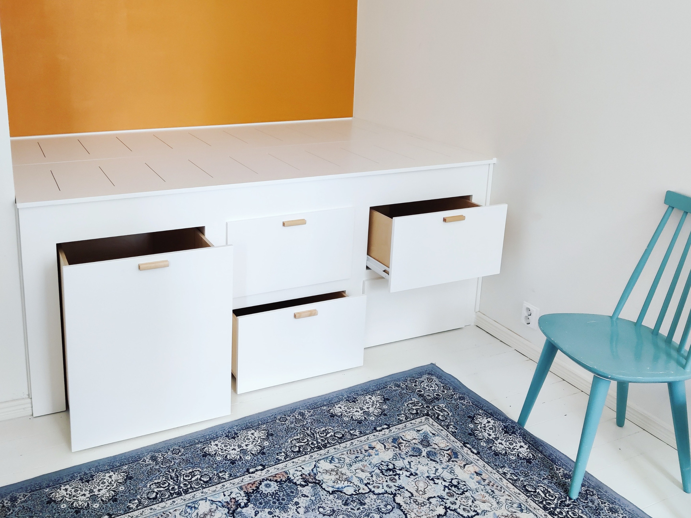 Korotettu sänky jossa kiskolliset vetolaatikot kahdessa kerroksessa