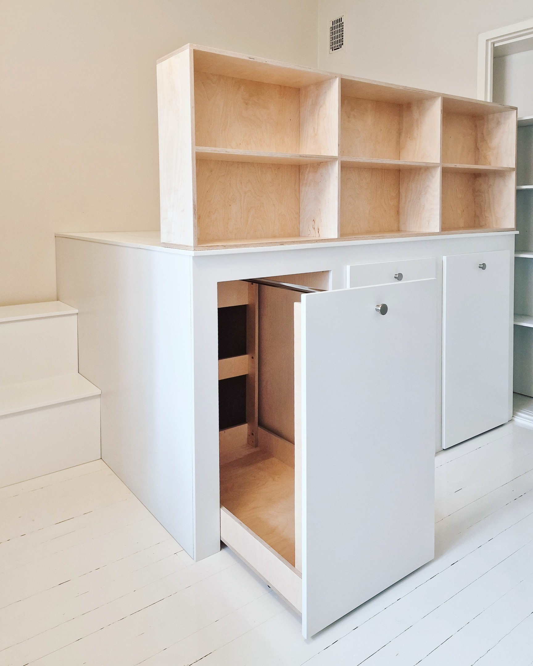 korotettu sänky jonka alla vaatetangot