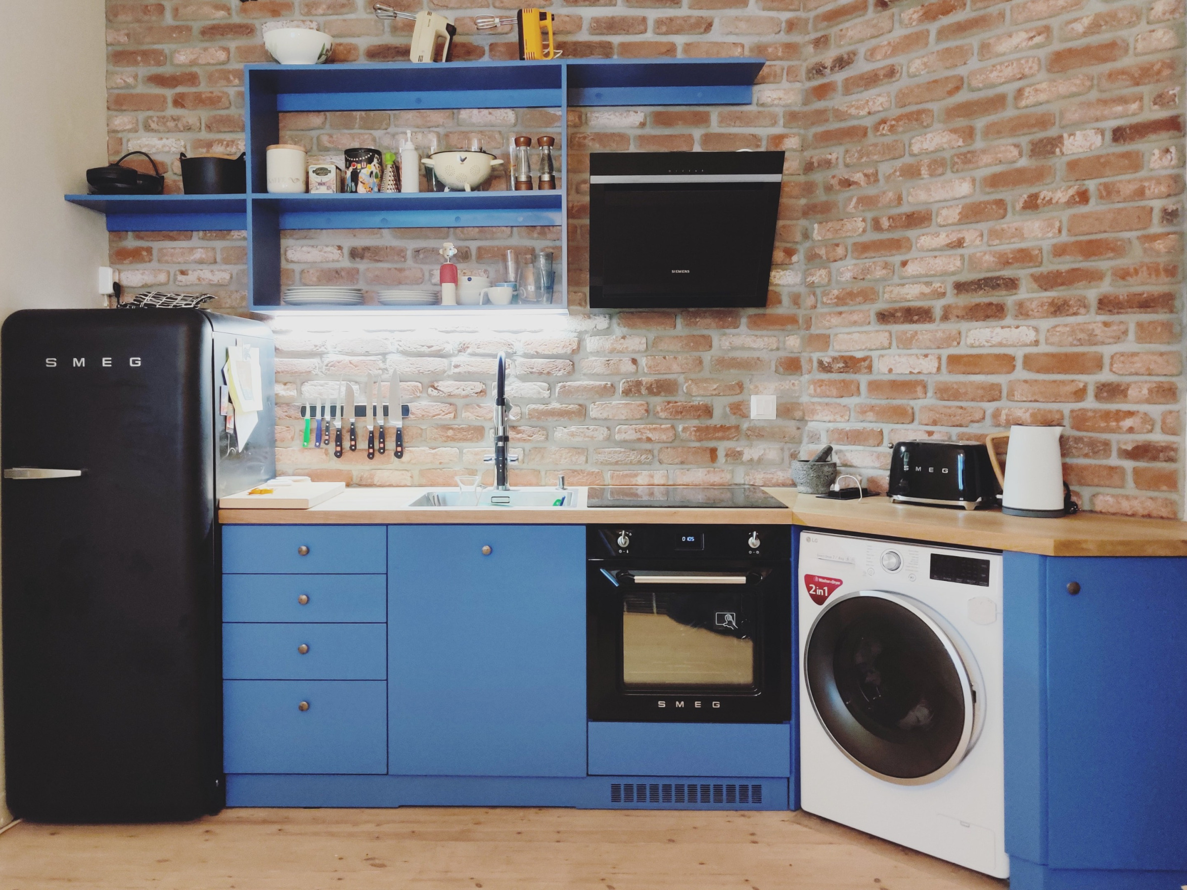 Korotettu sänky vaatetangollisilla vetolaatikoilla ja kirjahyllyllä