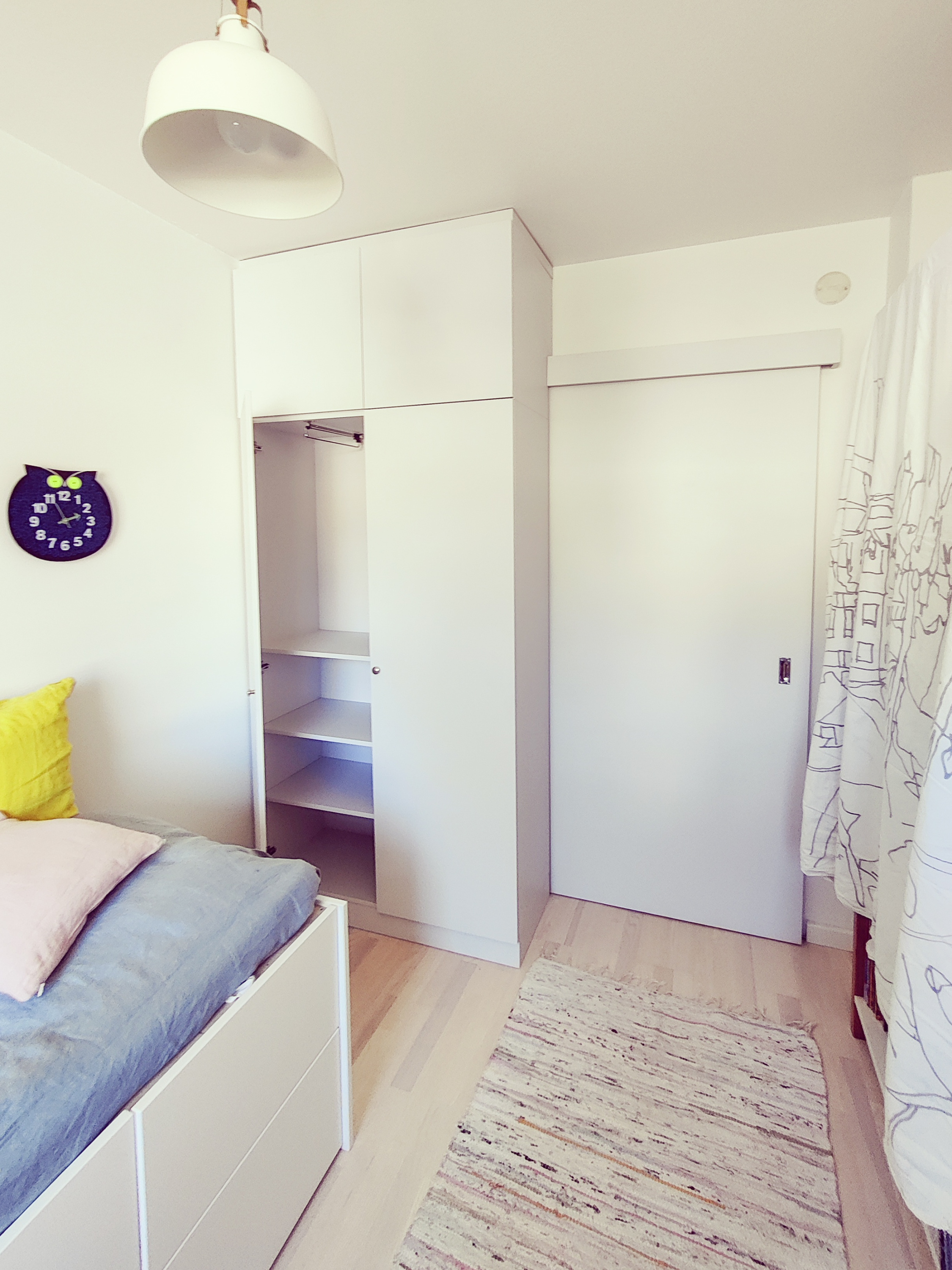 Kirjahylly koivusta maalattuna. Alhaalla kehysovelliset kaapit, yläpuolella tila tv:lle ja korkeussäädettävät hyllylevyt.