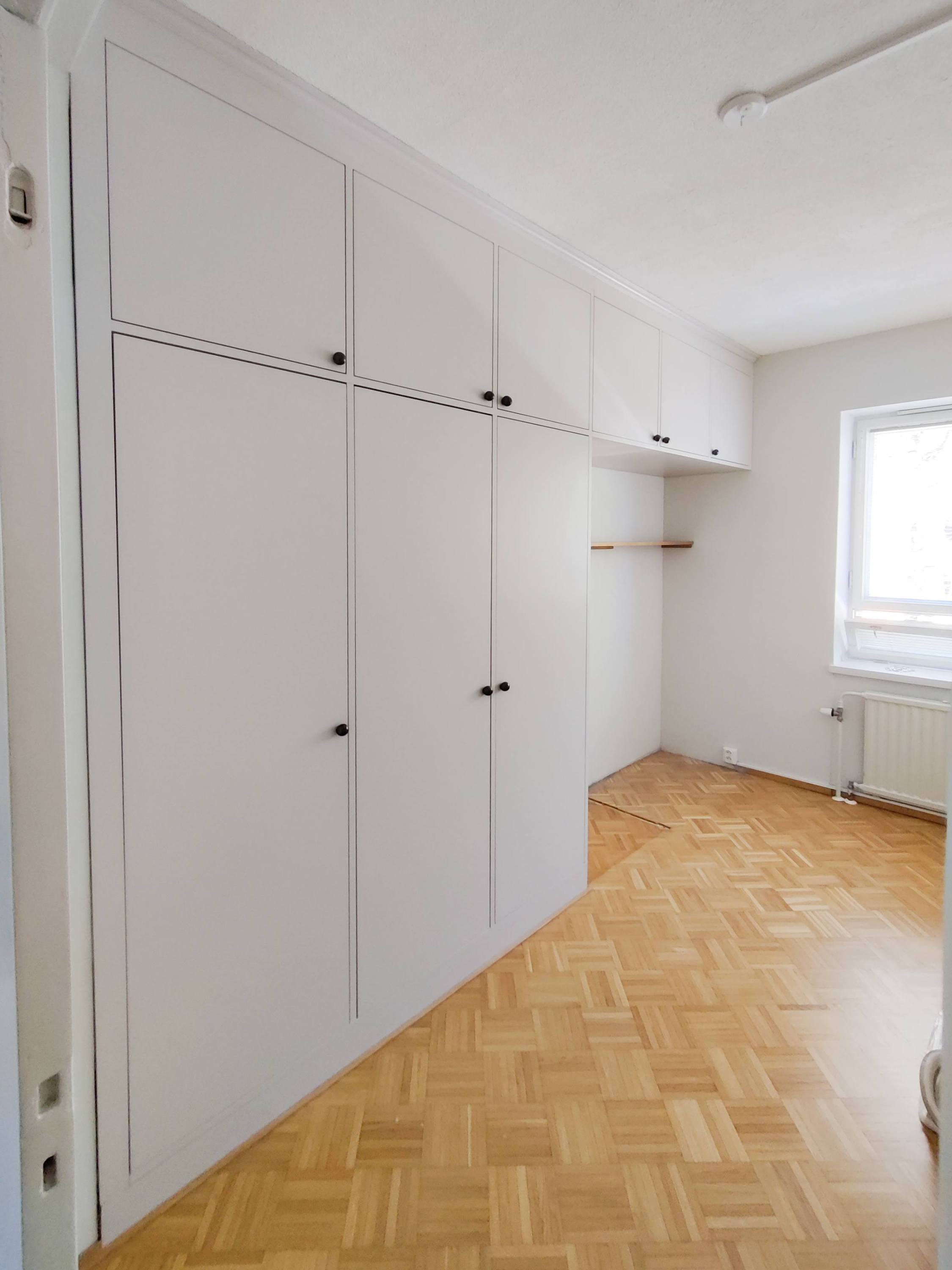 Build-in kirjahylly lasiovilla ja vetolaatikoilla sekä alakaapeilla.