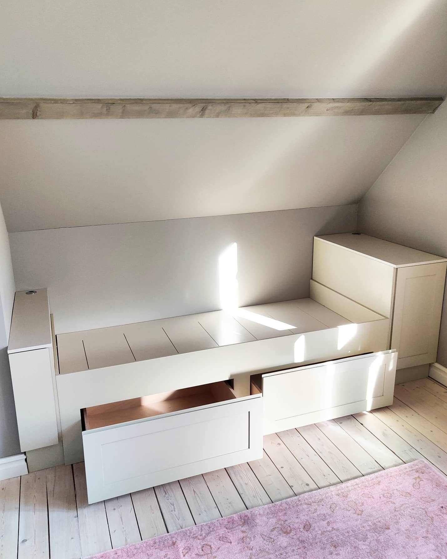 Korotettu sänky vetolaatikoilla, päädyissä kaapit