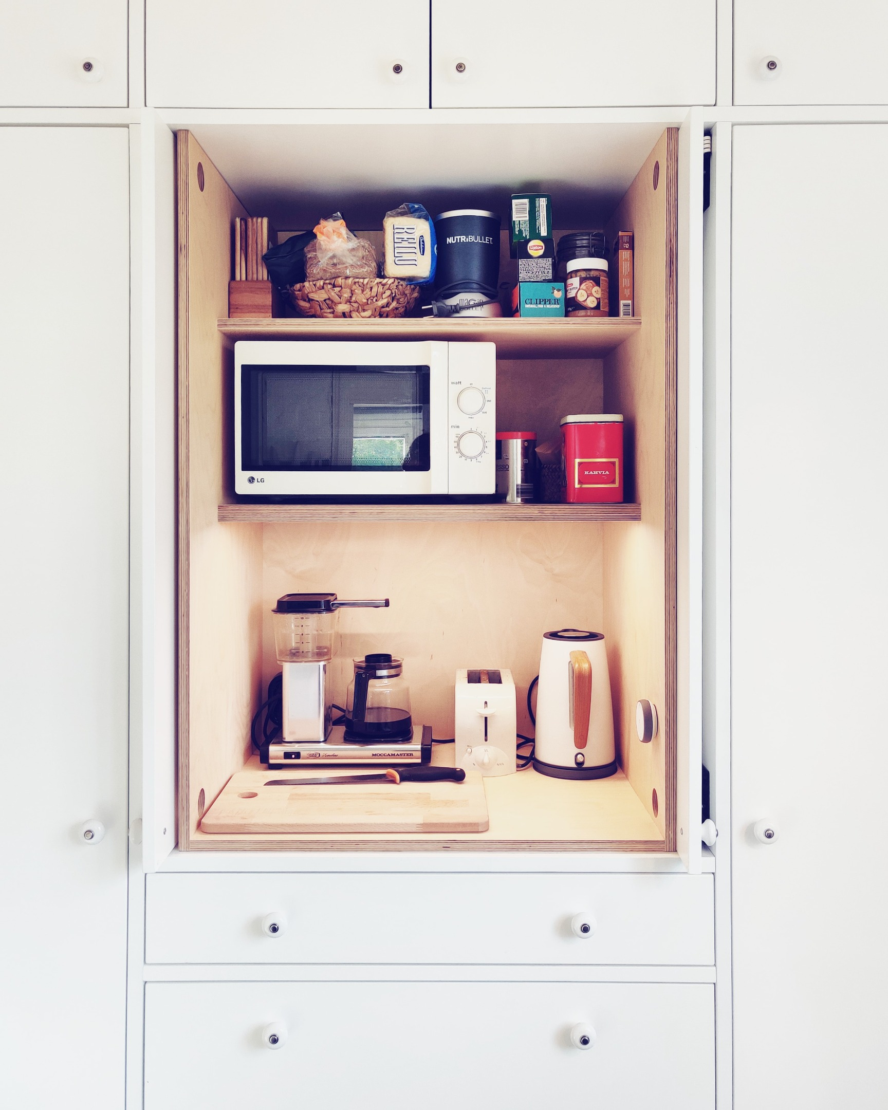 Alkovin korotettu sänky, edessä rimaseinä, portaat ja kaksi isoa pyörällistä vetolaatikkoa