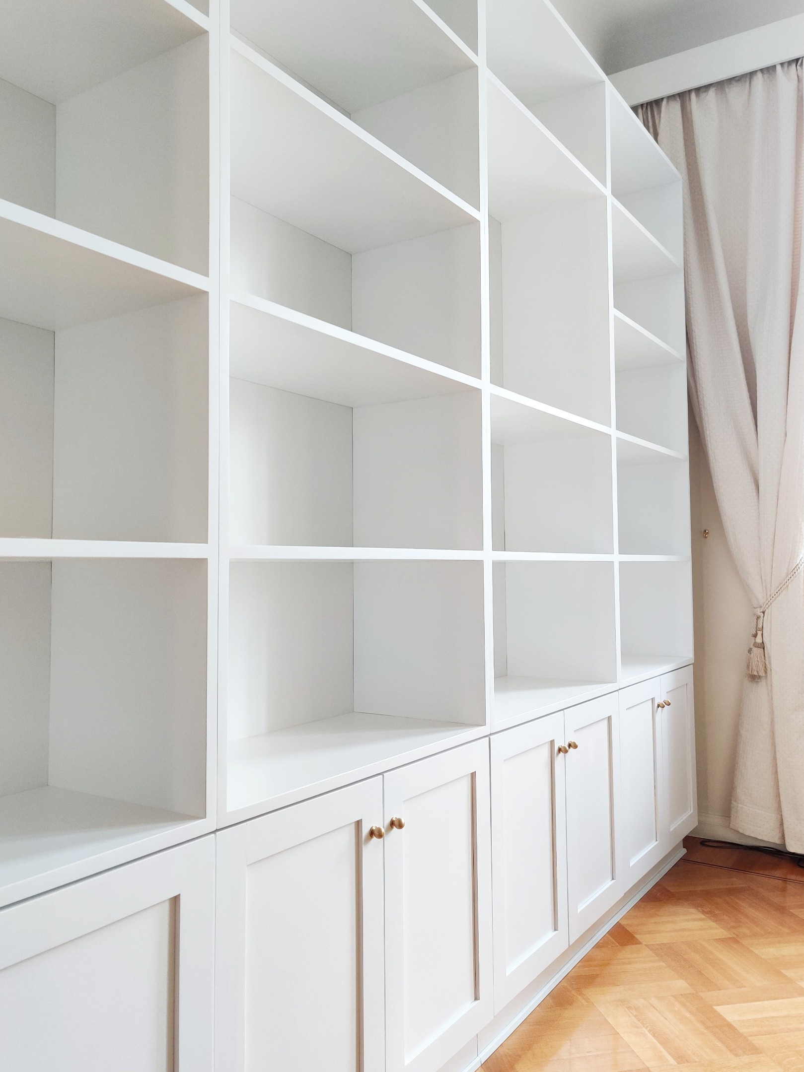 Kirjahylly koivusta. Alla kehysovelliset kaapit, yläosassa kiinteät hyllyt. 